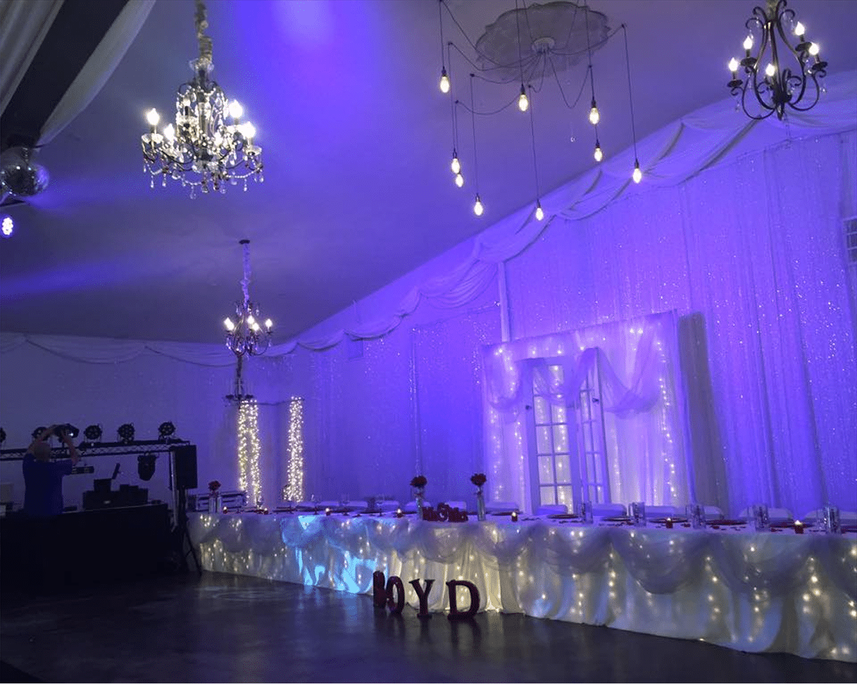 Party venue with decorative lights and a stage setup for entertainment.