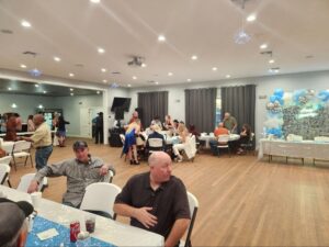 Indoor party with guests, decorations, and balloons.