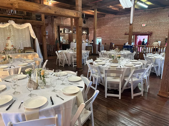 Elegantly set tables in rustic banquet hall. 