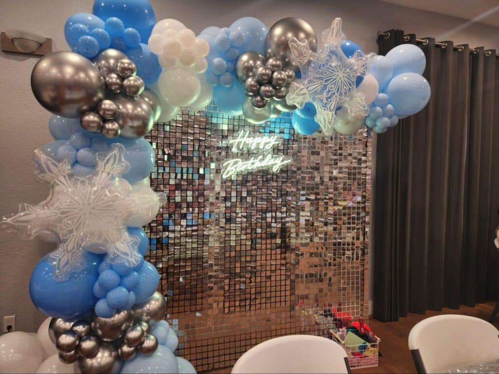 Birthday balloon arch with shimmering backdrop display.